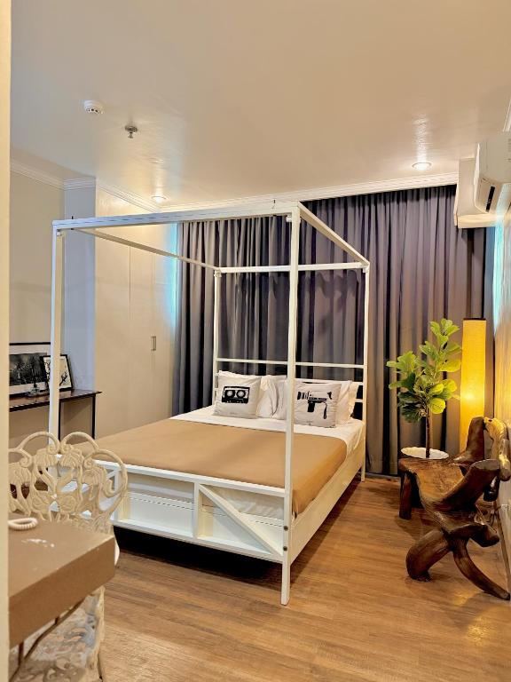 a bedroom with a white canopy bed in a room at Hotel Tiffany - Laoag in Laoag