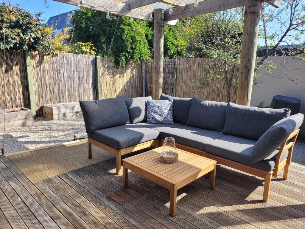 a couch and two chairs and a table on a patio at Queen's Landing in Nelson
