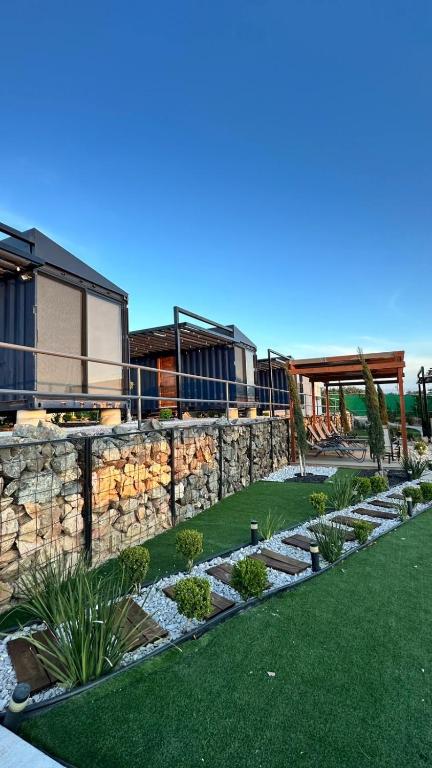 a yard with a stone retaining wall and a garden at cabañas aldebaran in Ciénega Redonda
