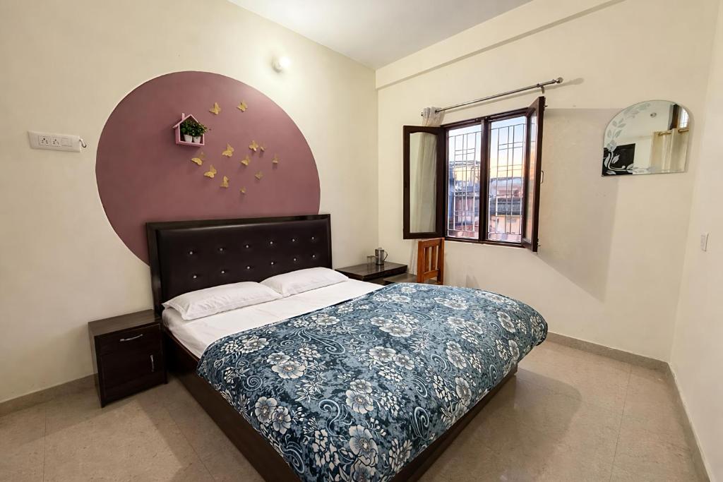 ein Schlafzimmer mit einem großen Bett mit lila Kopfteil in der Unterkunft Gomukh Hotel Uttarkashi in Uttarkāshi