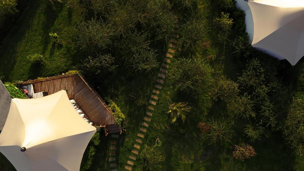 an overhead view of two white umbrellas on a hill at Hemma Genki Luxury Wellness Hotel Villa in Villa de Leyva