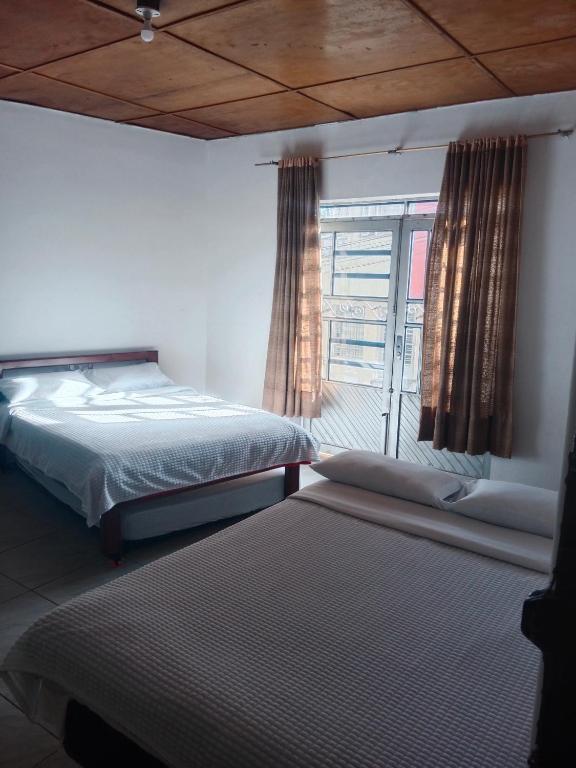 a bedroom with two beds and a window at Apartaestudio Central in Chiquinquirá