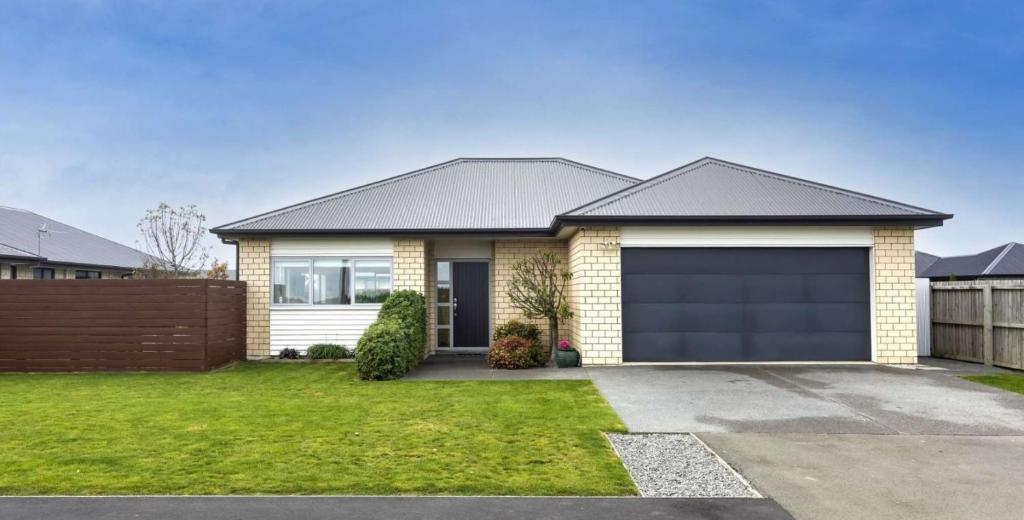 a house with a garage in a yard at Rana Niwas in Rolleston