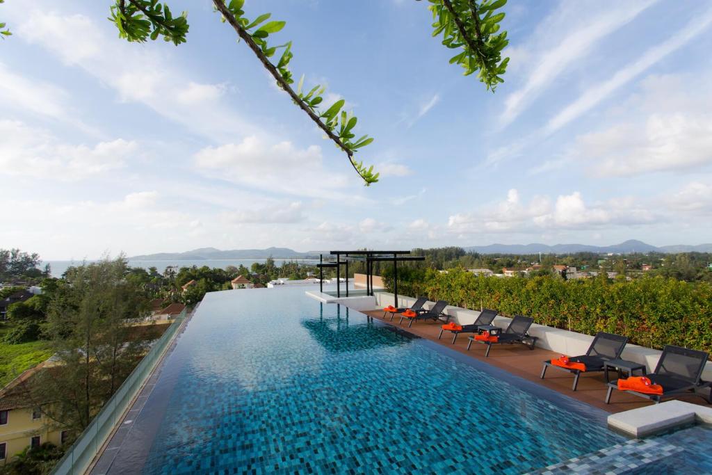 a view of a swimming pool with chairs and trees at Surin Condo Walk to Beach with Rooftop Pool - C416 in Ban Lum Fuang