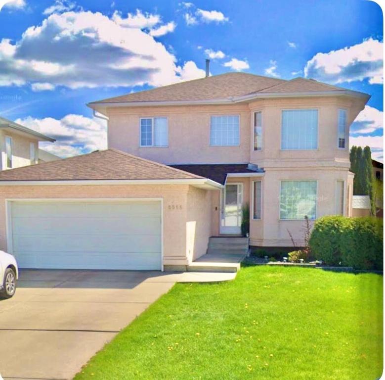 a large house with a garage in the yard at Belle-Rive - family friendly Guest House in Edmonton