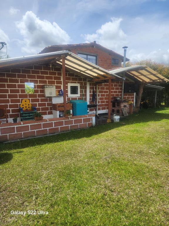 a brick house with a roof on a yard at villa lyda in San Vicente