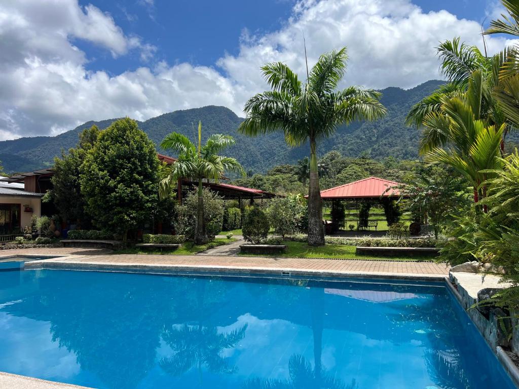 a swimming pool in front of a house with mountains at La Quinta de Andrés in San Isidro