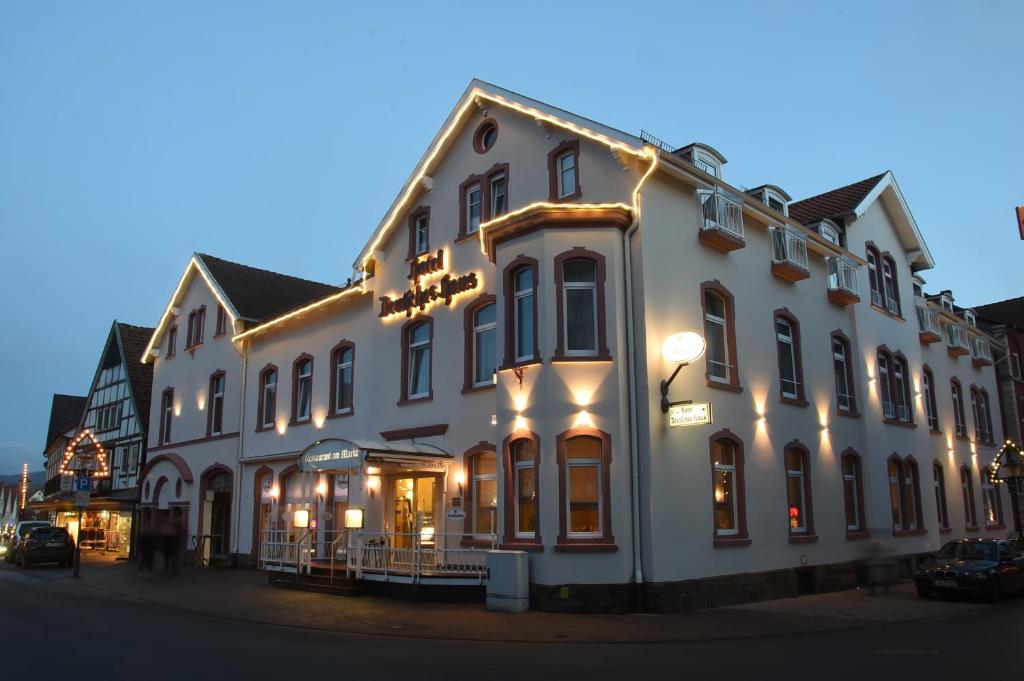 a large white building with lights on a street at Hotel Deutsches Haus in Blomberg