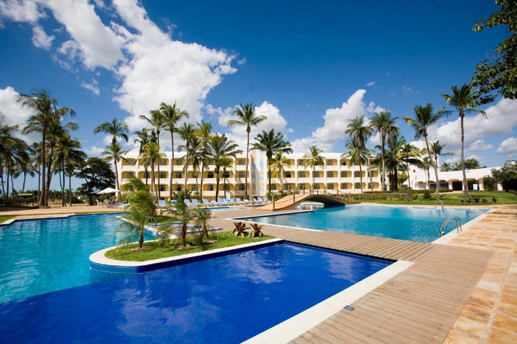 a resort with a large swimming pool with palm trees at Blue Tree Towers São Luis in São Luís
