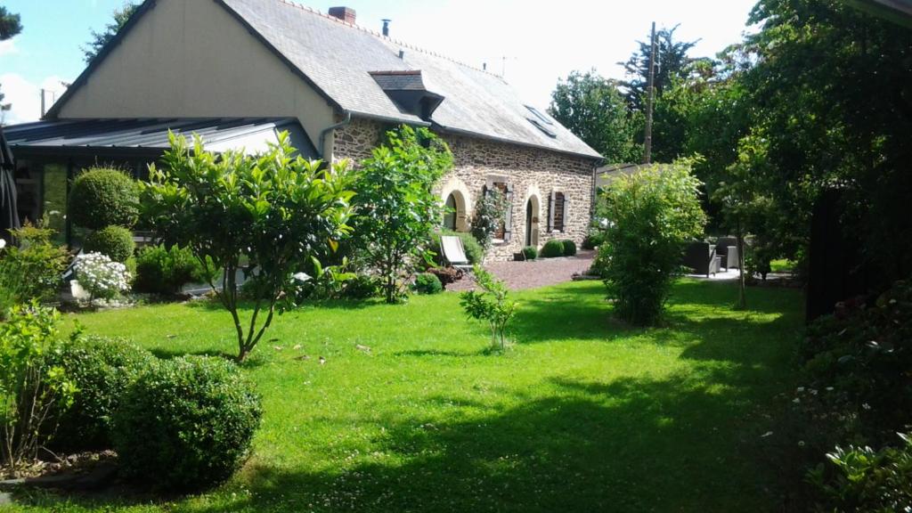 een huis met een tuin met groen gras bij Patis De Cahot au 108 in Bruz