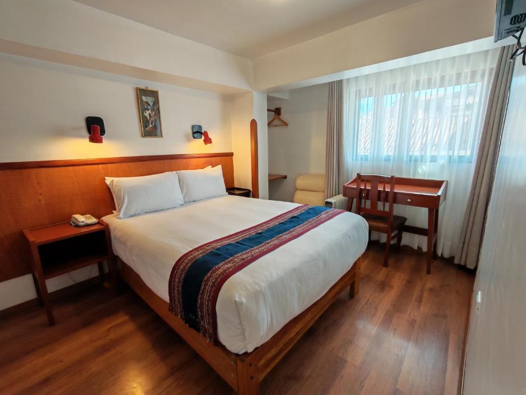a bedroom with a large bed and a desk at Saphi Inn Cusco - Excelente ubicación in Cusco