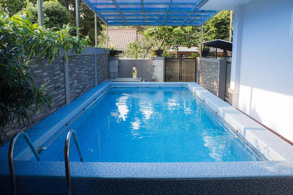 a large blue swimming pool in a backyard at Salak Cozzy Stay Managed by Salak Hospitality in Kamparganya