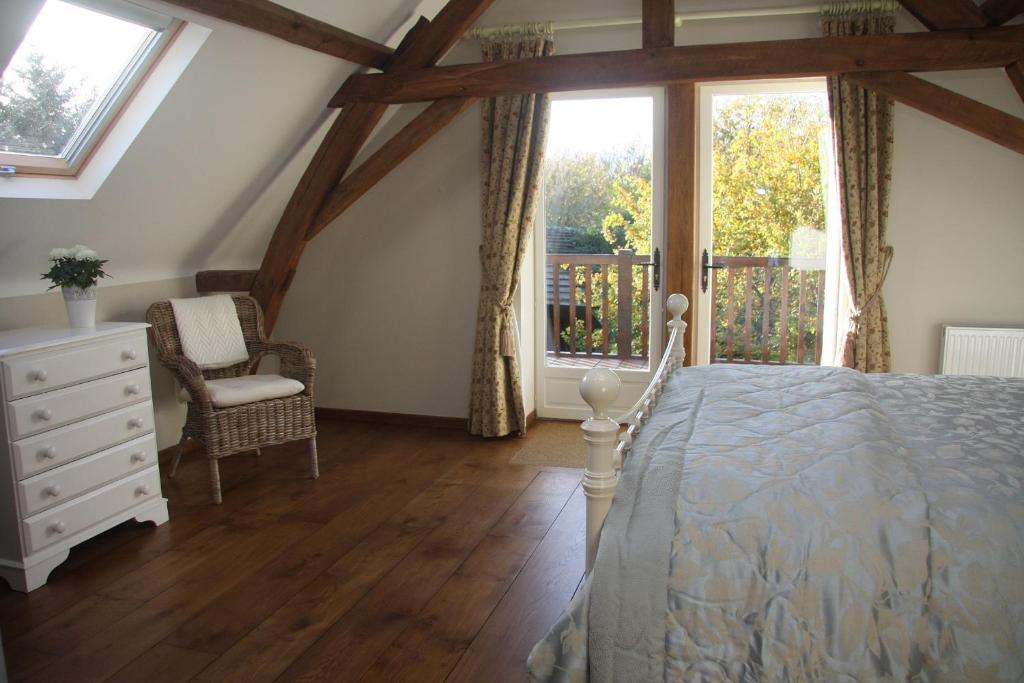 a bedroom with a bed and a large window at Les Bouts de Rallé Chambre d&#39;Hotes in Sainte-Osmane