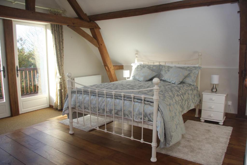 a bedroom with a white bed and a window at Les Bouts de Rallé Chambre d&#39;Hotes in Sainte-Osmane