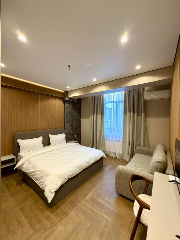 ein Schlafzimmer mit einem großen Bett und einer Couch in der Unterkunft Hotel Elora in Almaty