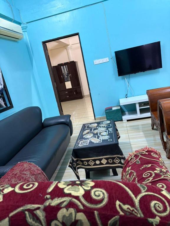a living room with a couch and a tv at De JITRA 2 HOMESTAY in Jitra