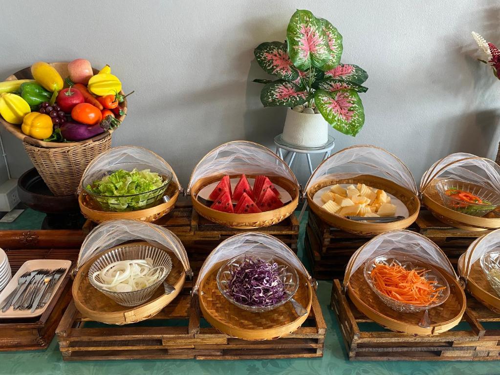 A colourful buffet display of fresh vegetables, fruit and salad ingredients.