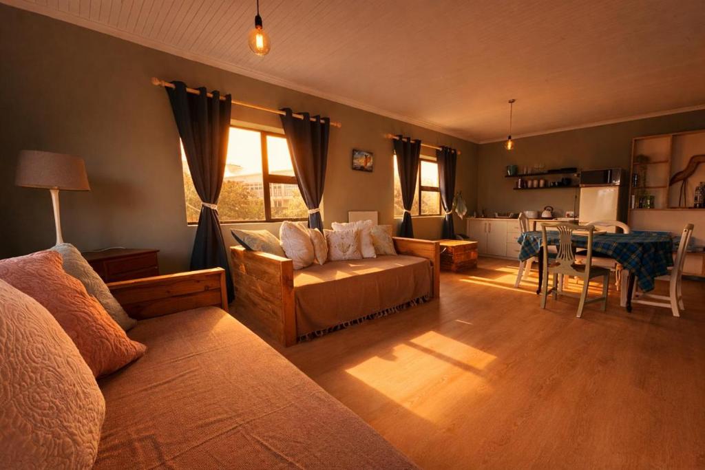 a living room with a couch and a dining room at At the Indi in Struisbaai