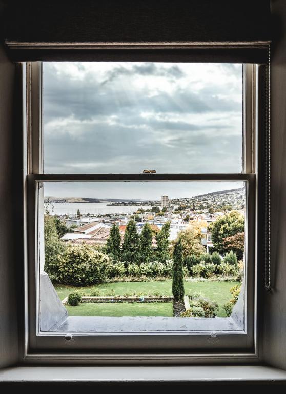 a window with a view of a city seen through it at Old Bishop's Quarters in Hobart