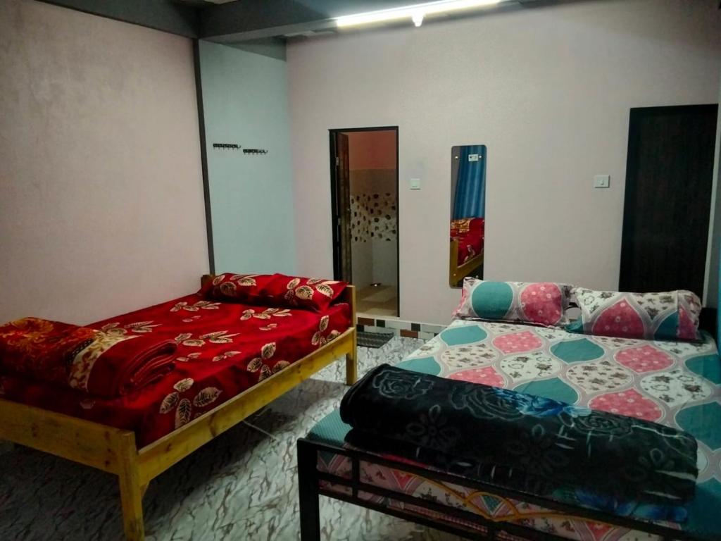 a room with two beds and a couch in it at Urisha homestay in Mawlynnong