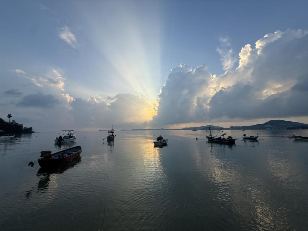 a group of boats sitting in the water with the sunset at Spectacular Sunrise and Mountain Views in Mae Nam