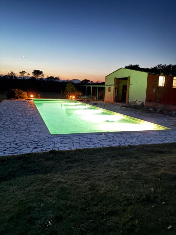 a swimming pool in a yard at night at B&B El Ranxo in Franciach