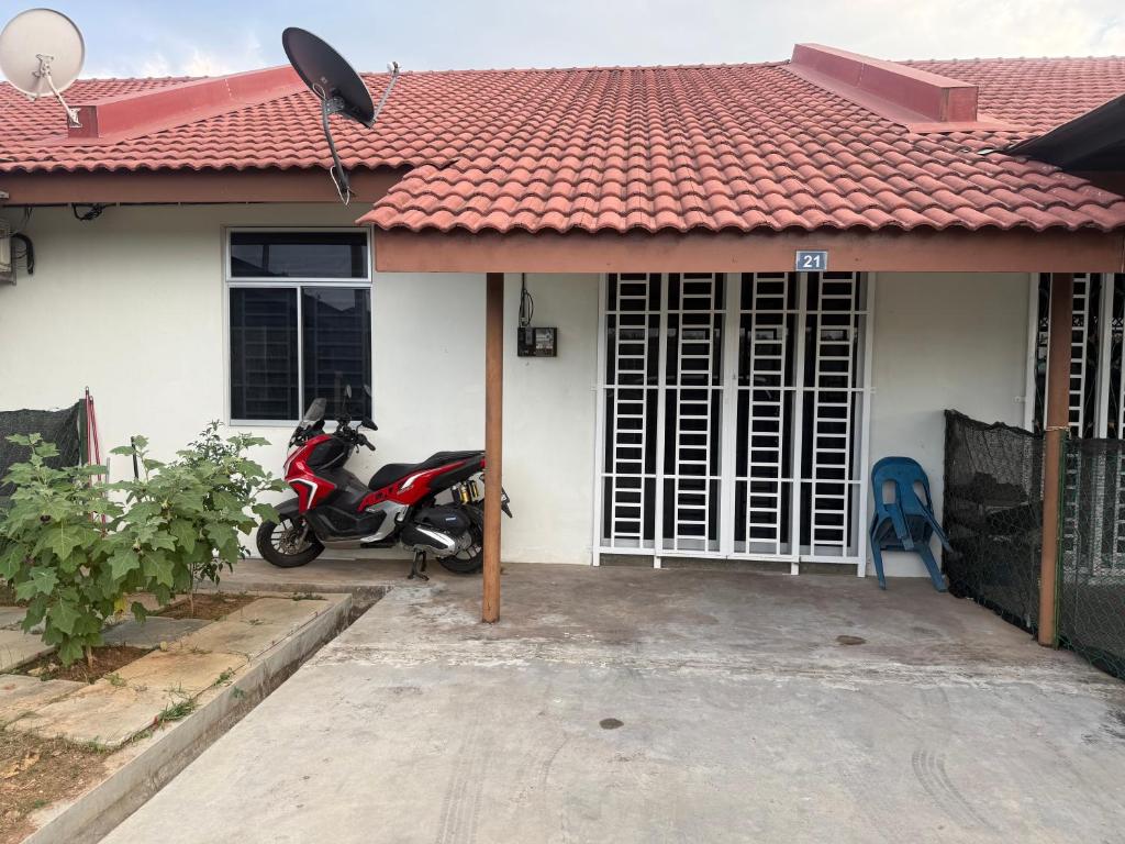 a motorcycle parked in front of a house at DF Homestay in Kangar