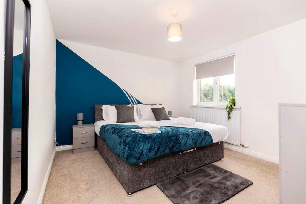 a bedroom with a bed with a blue accent wall at Modern 3BR Durham Stay for Work Trips in Brandon