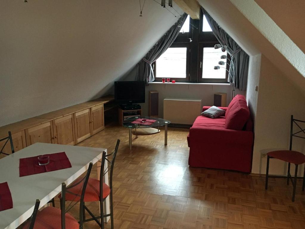 a living room with a red couch and a table at Ferienhaus FachWerk in Holler