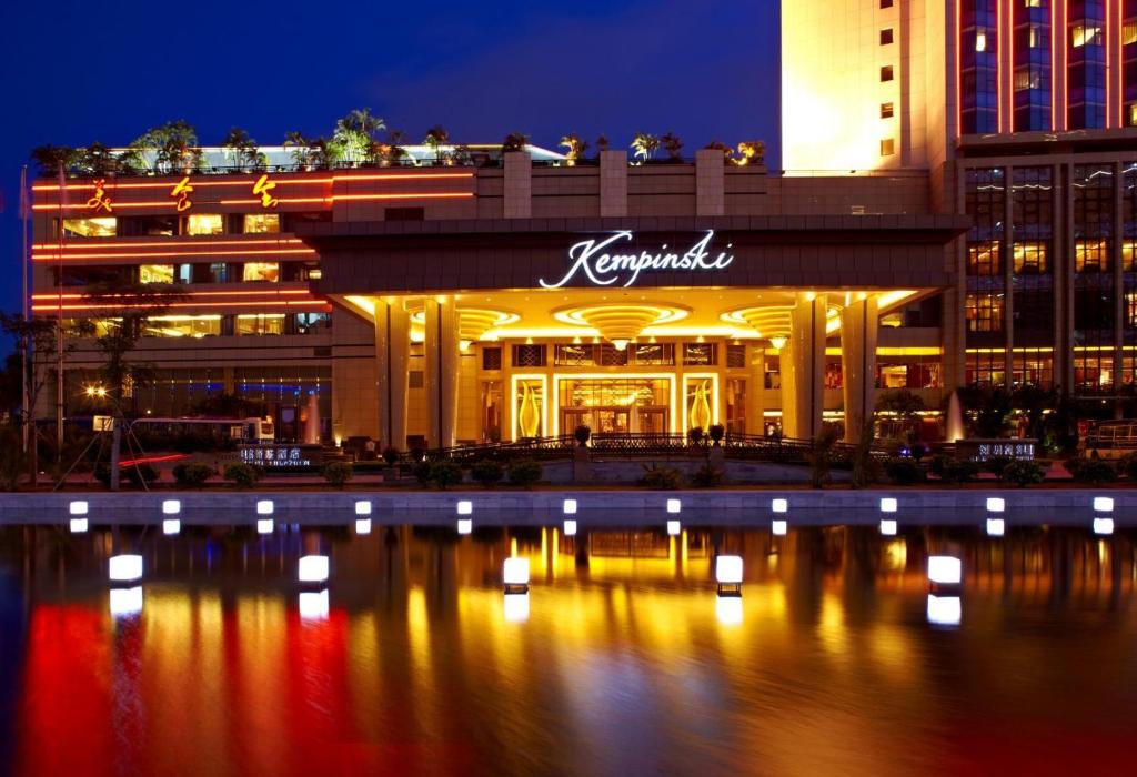 a hotel at night with a reflection in the water at Kempinski Hotel Shenzhen in Shenzhen