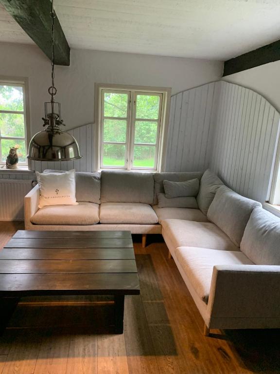 a living room with a large couch and a table at Haus Siebenstein Living for a good cause in Drochtersen