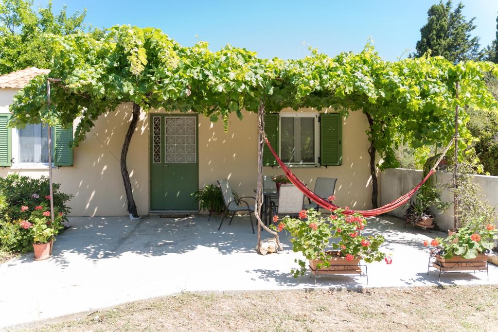 a house with a pergola with a bunch of grapes at Joya's Little Farm Cottage in Svoronata