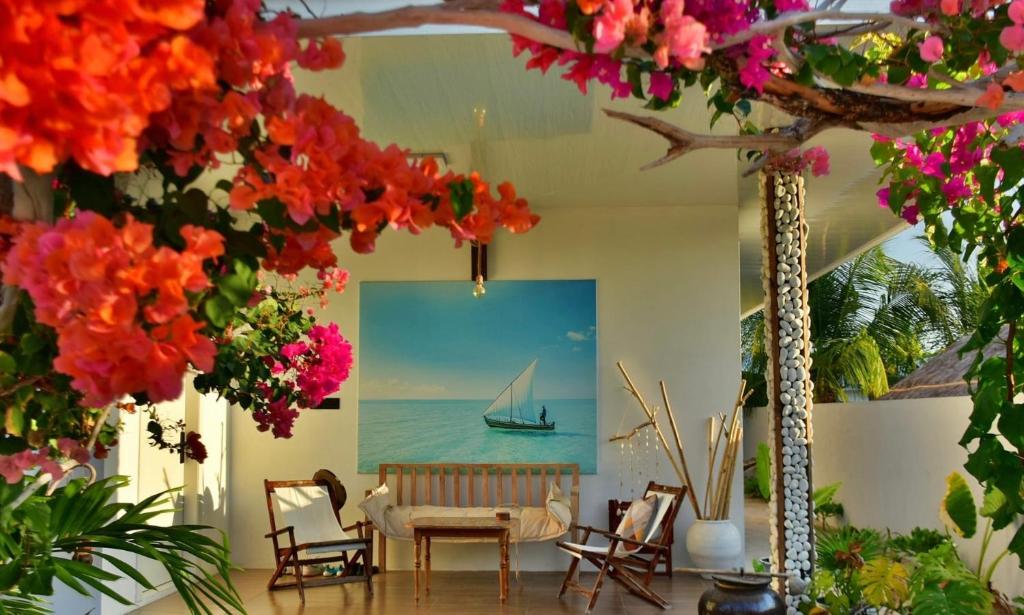 a room with a table and chairs and flowers at Crystal sea inn in Bileffahi