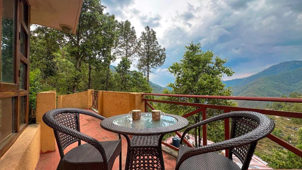 a table and chairs on a balcony with a view at Pillow on the Cloud in Rāmgarh