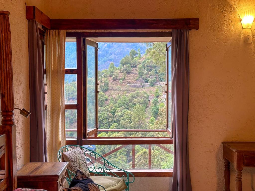 a window in a room with a view of a mountain at Bird Songs in Rāmgarh