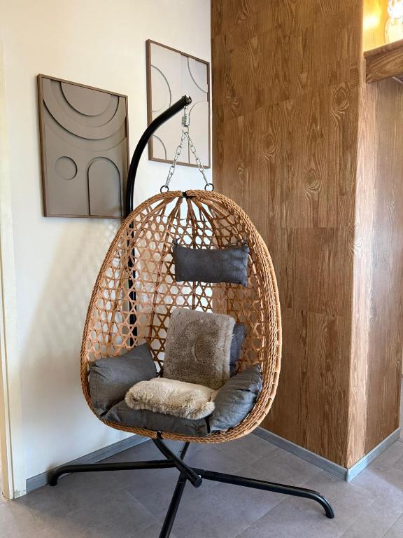 a wicker swing chair sitting in a room at Colombo 49 Guest House in Gallarate