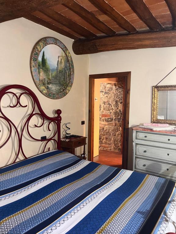 a bedroom with a bed and a dresser and a mirror at W il silenzio! in Gualdo