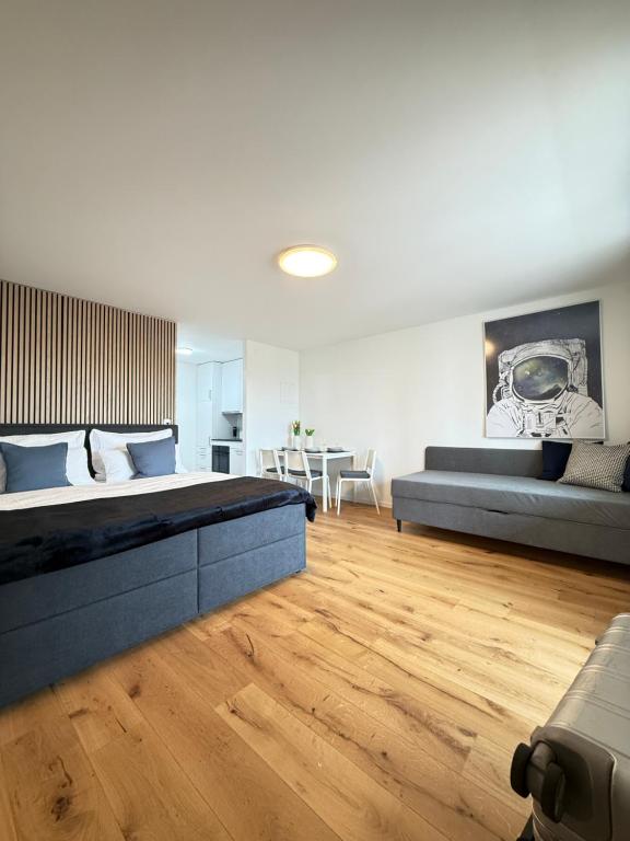 a large bedroom with a large bed and a couch at HRE Apartments Rorschach - Self Check-In in Rorschach