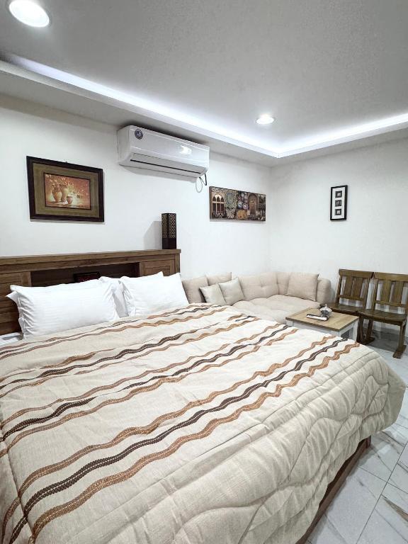 a bedroom with a large bed and a couch at Velmora Villas Room 12 in Abu Dhabi