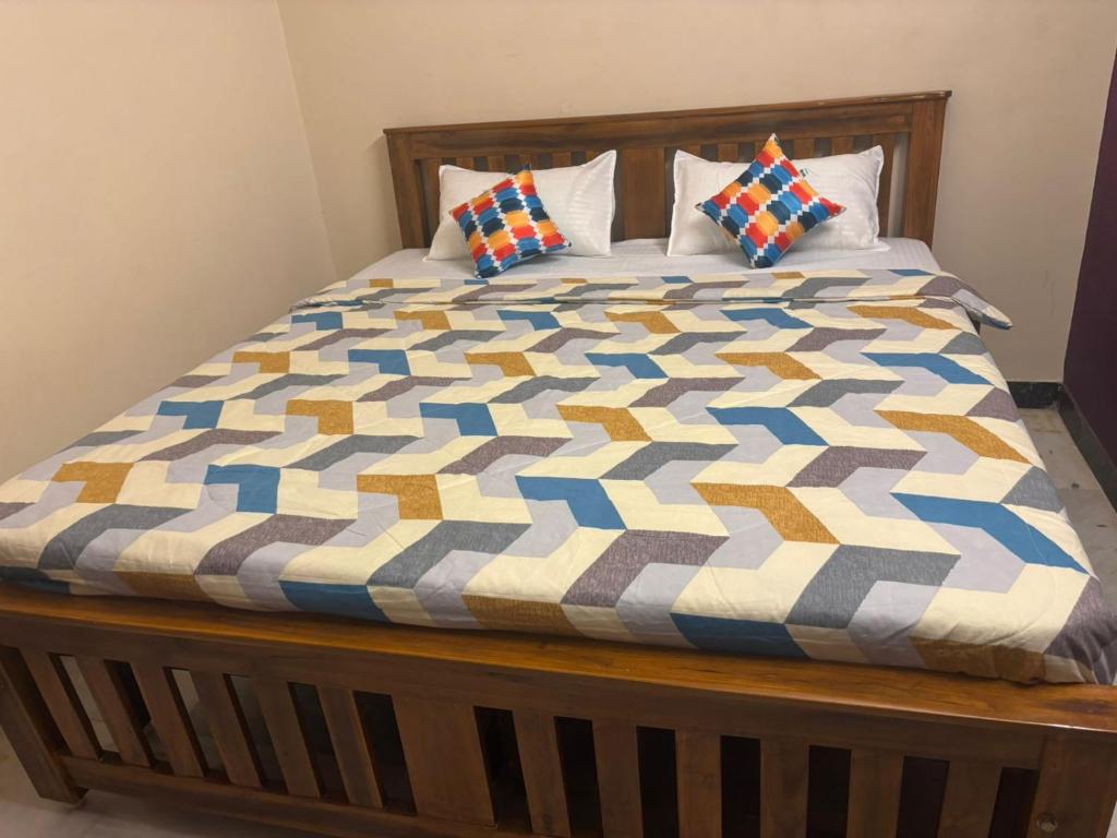a bed with a colorful quilt on top of it at IP - Malar in Pondicherry