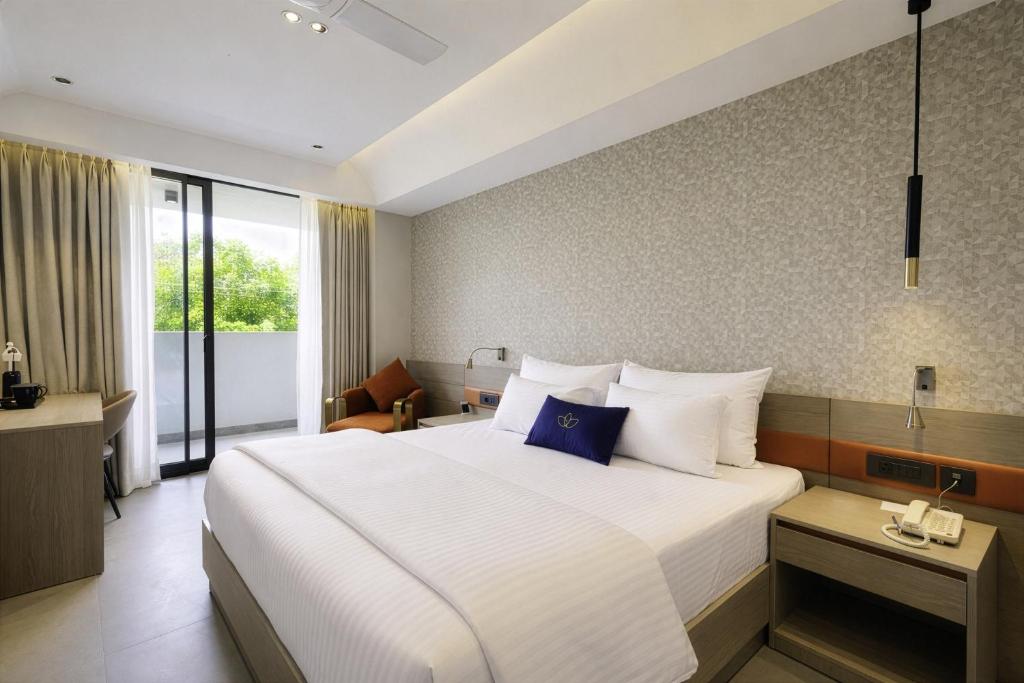 a bedroom with a large bed with a blue pillow at Grand Continent Hotel, Near Sector 44, Gurugram in Gurgaon