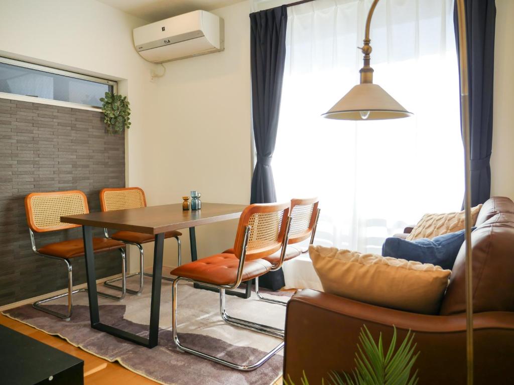a living room with a table and chairs and a couch at MSTAY池袋one in Tokyo