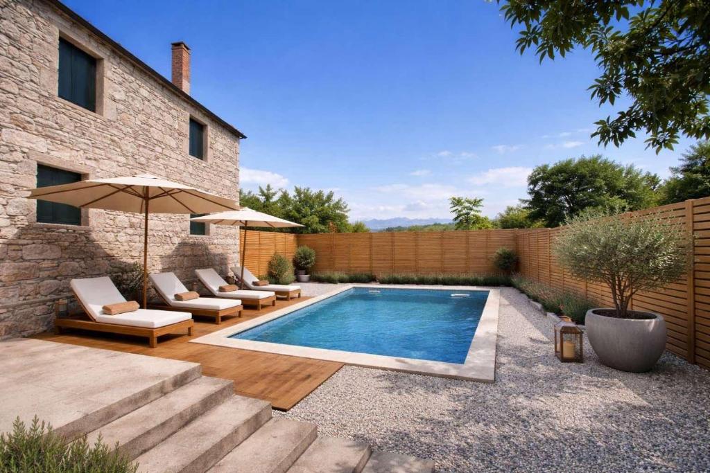 a swimming pool with lounge chairs and an umbrella at Villa Jakov in Podgorica