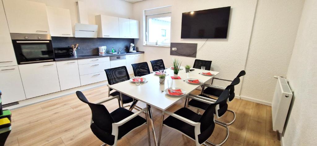 a dining room table and chairs in a kitchen at Großzügiger Wohntraum mit 4 Schlafzimmern nur 8 Gehminuten vom Europa-Park in Rust
