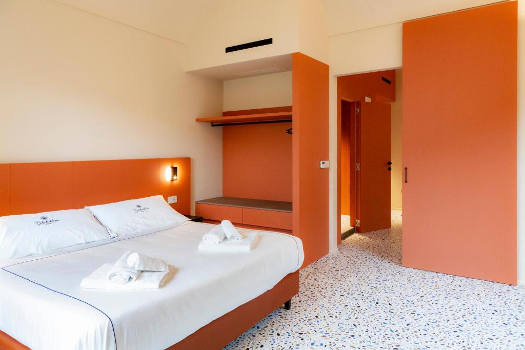 a bedroom with a bed with two towels on it at Ghibellini Rooms in Palazzolo Acreide