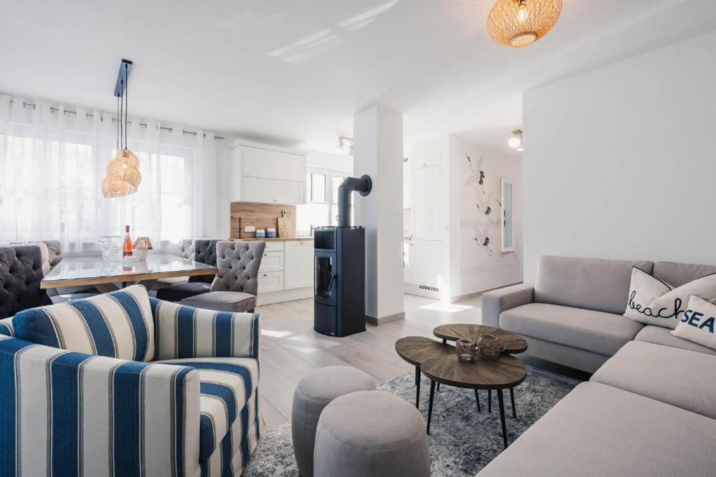 a living room with a couch and chairs and a kitchen at Kranichkieker in Zingst