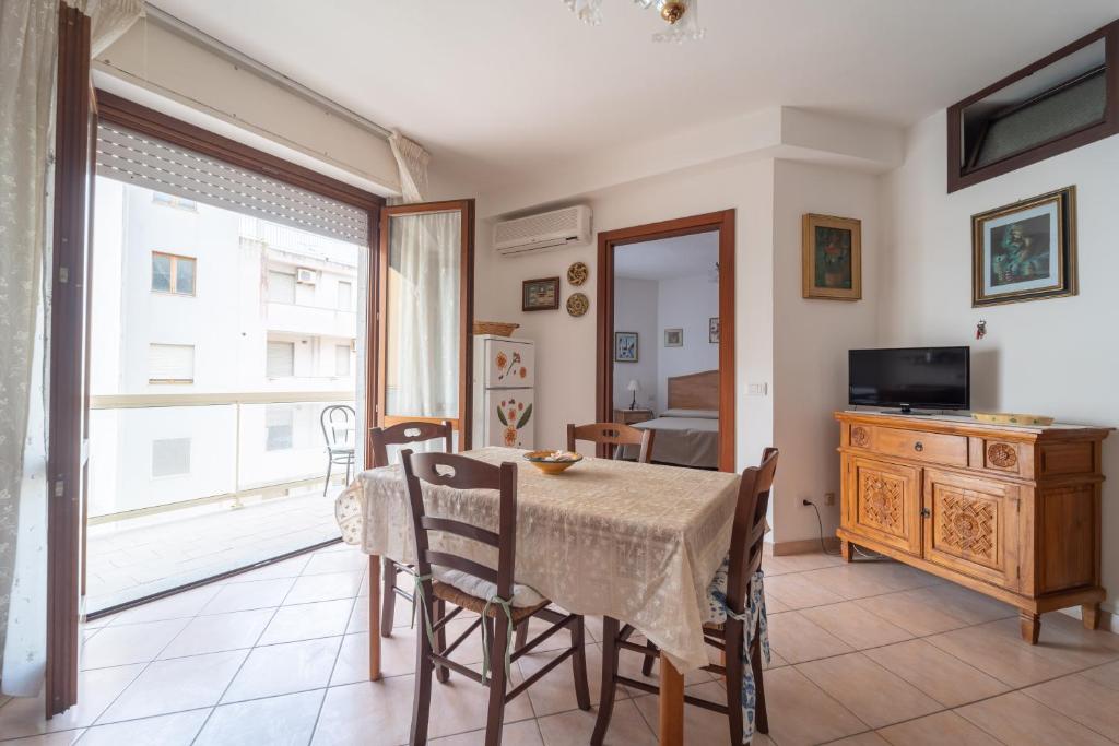 a dining room with a table and chairs and a window at Rubens in Alghero