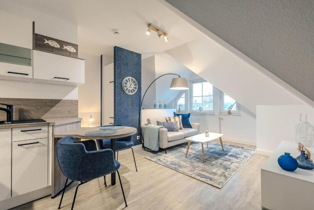 a kitchen and living room with a table and a couch at Lee in Zingst