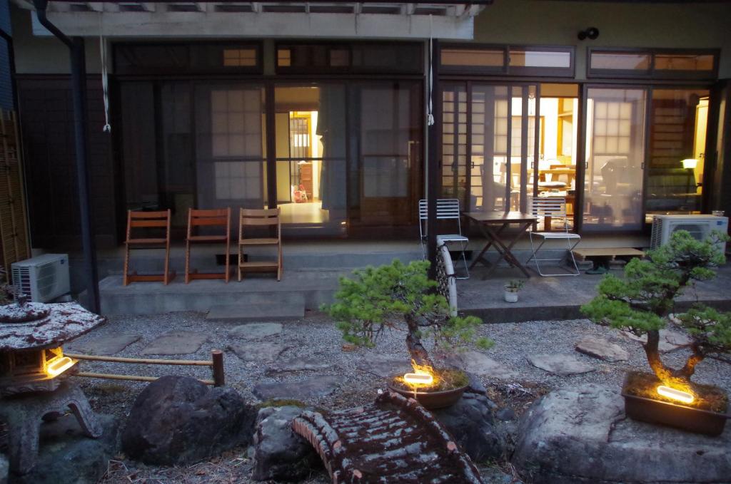 a house with two bonsai trees in a yard at DON chan GuestHouse Nikko ,7 minutes walk from Imaichi Station in Nikko