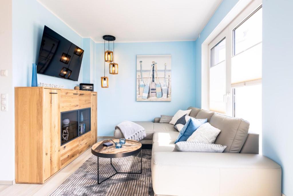 a living room with a couch and a tv at Ostseelodge zwei in Fuhlendorf